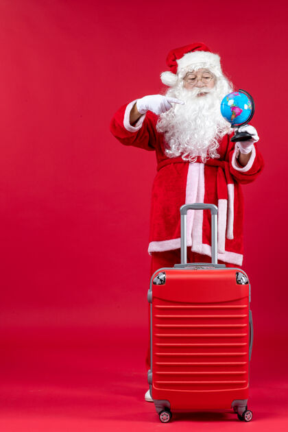 准备圣诞老人的前视图 包里装着小地球仪 准备在红墙上旅行旅行圣诞老人肖像
