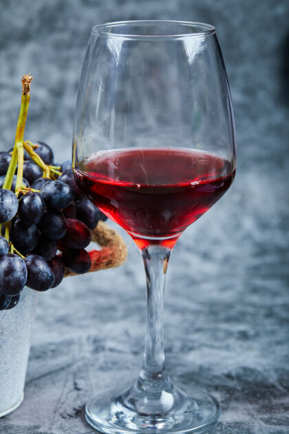 液体一杯红酒放在大理石背景上 配上葡萄高质量的照片酒吧酒庄葡萄酒