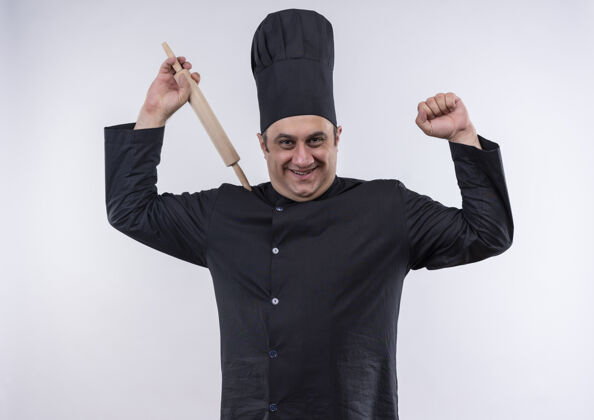 中年笑容可掬的中年男厨师身着厨师制服举起擀面杖显示出坚强的姿态手势提高男性