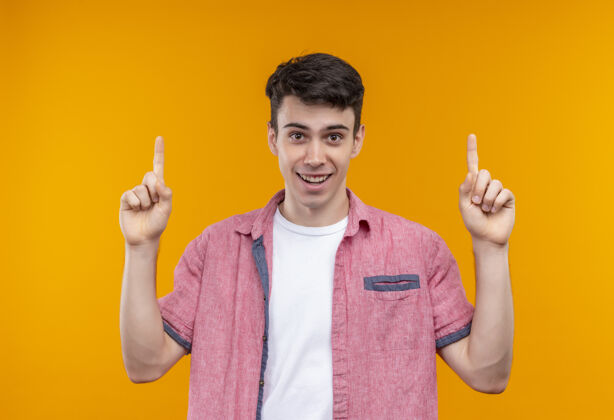 小伙子微笑的白人年轻人穿着粉色衬衫指着孤立的橙色背景穿着橙色点