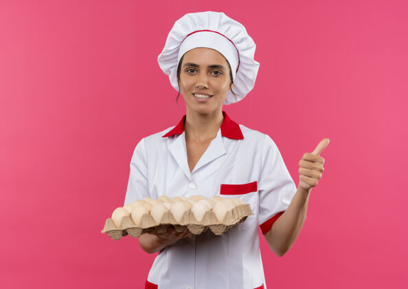鸡蛋面带微笑的年轻女厨师穿着厨师制服 手里拿着一批鸡蛋 大拇指朝上 留着复印空间批女向上