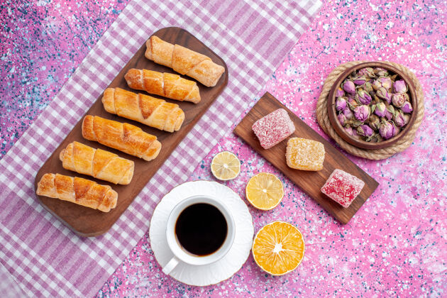 面团在粉红色的桌子上可以看到美味的百吉饼和一杯茶盘子粉色蛋糕