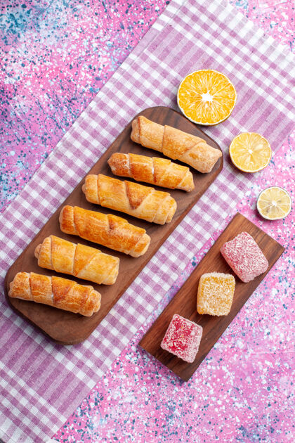 糕点在粉红色的背景上俯瞰美味的百吉饼和果酱粉色肉果酱