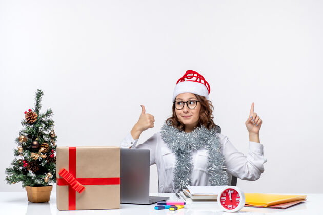 圣诞节正面图：年轻的女工坐在她工作的地方前面 背景是白色的坐着电脑视图