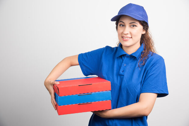 微笑送披萨的女孩拿着三个白色背景的盒子工人帽子盒子