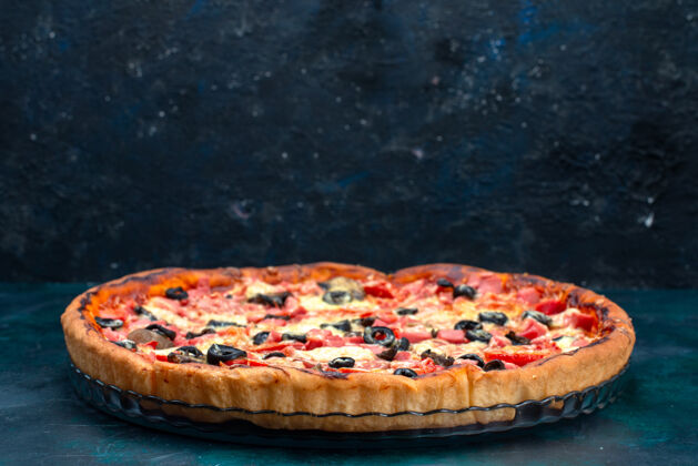 美味蓝色桌子上烤着美味的披萨 上面放着橄榄香肠和奶酪酱汁午餐前面