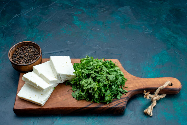 绿色前视图：深蓝色背景上有白色奶酪和新鲜绿色奶酪新鲜蓝色