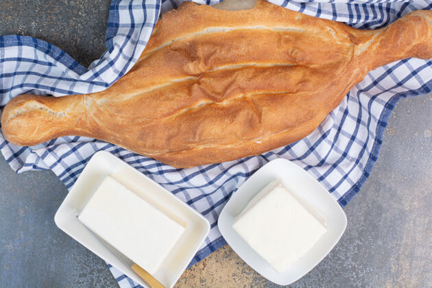 风景面包和两盘奶酪放在桌布上刀面包美味