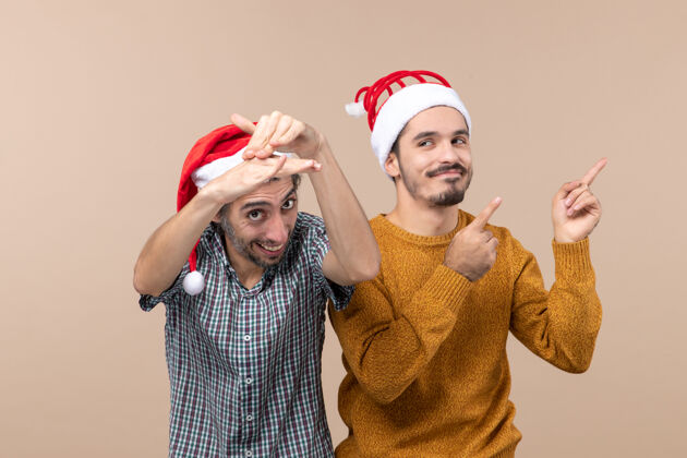帽子正面图：两个微笑的男人 戴着圣诞帽 背景孤立视图一起男人