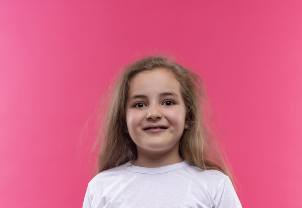 微笑微笑的小女生穿着白色t恤 背景是孤立的粉色穿着T恤小