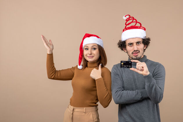 情绪圣诞心情激动情绪满足酷酷情侣戴红色圣诞老人帽出示银行卡展示帽子酷