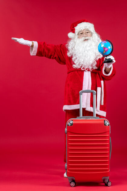 快乐红墙上准备旅行的圣诞老人的前视图圣诞包成人