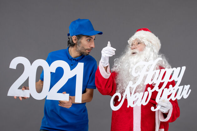 圣诞快乐圣诞老人与男信使举行和新年快乐和2021年板灰墙的正面视图快乐人们圣诞老人
