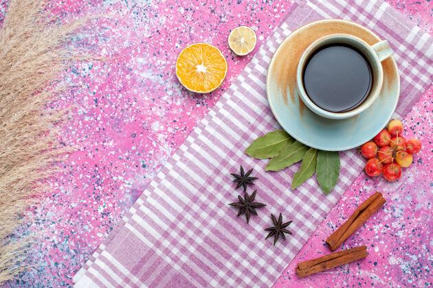 水果顶视图一杯带有肉桂和樱桃的茶 浅粉色背景 茶饮料呈水果色布料上衣饮料