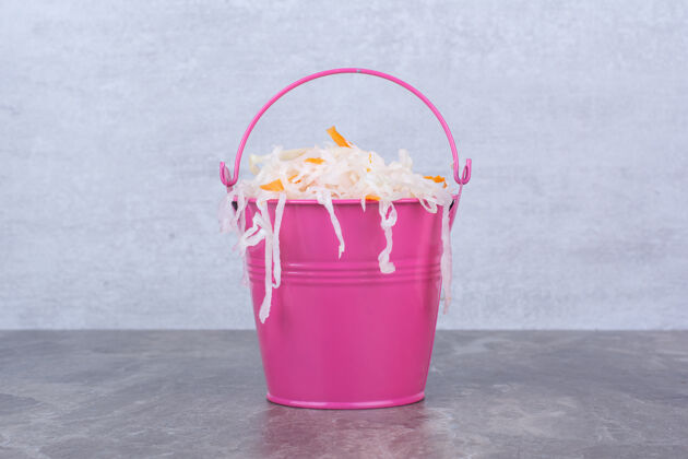 卷心菜美味的自制泡菜在粉红色的桶里切碎的腌制的食品
