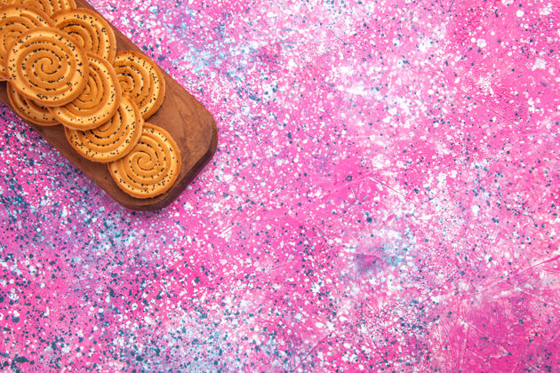 小粉红色表面上排列的圆形甜饼俯视图手镯糖黄金