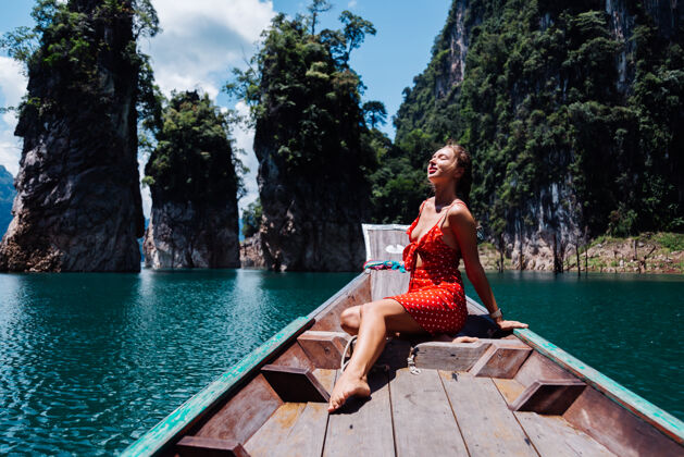 山穿红色夏装的高加索女子在泰国亚裔船上度假 环游泰国湖泊自然国家