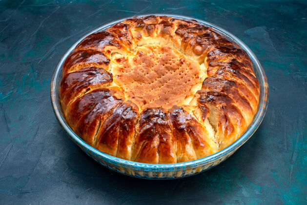蛋糕前视图美味的烤蛋糕圆形形成甜内浅蓝色背景上的玻璃锅烘焙糖菜