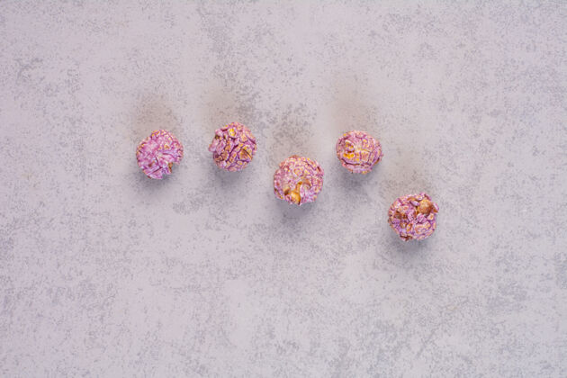顶部视图五颗爆米花糖排列在大理石上甜食顶部爆米花
