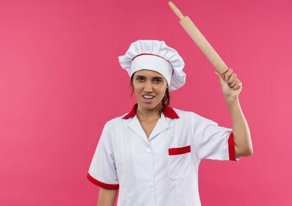 滚压未出租的年轻女厨师穿着厨师制服提高擀面杖与复制空间未出租厨师穿