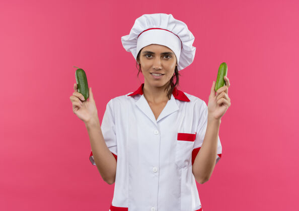制服面带微笑的年轻女厨师穿着厨师制服拿着黄瓜与复印空间黄瓜厨师拿着