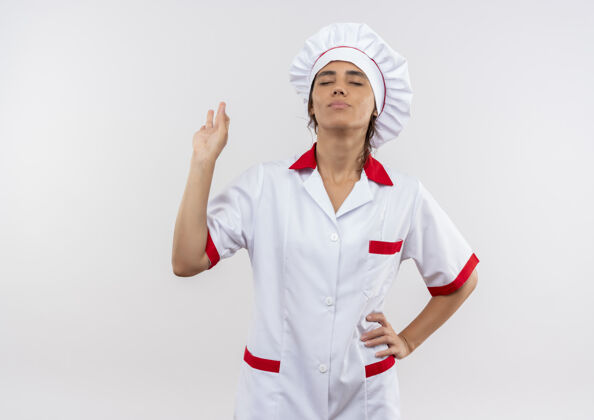 展示年轻的女厨师穿着厨师制服 闭上眼睛高兴地展示着模仿空间的奥基手势好的厨师关闭