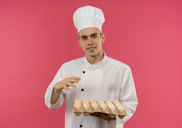 厨师高兴的年轻男厨师穿着厨师制服拿着一批鸡蛋厨师批男