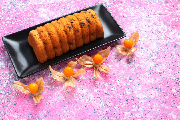 玉米半顶视图美味的烤蛋糕放在黑色的蛋糕锅里 粉红色的桌子上放着酸浆食物谷物粉色