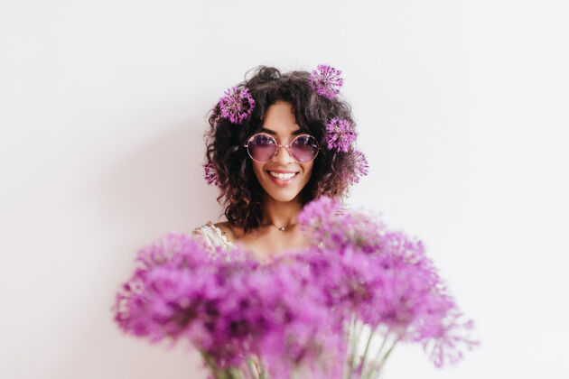 花带花束的漂亮黑人女孩带紫色蒜头的笑脸非洲女人的室内肖像成人时尚美国黑人