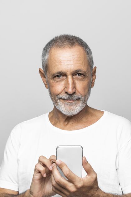 老年人特写笑脸男拿着智能手机自然特写男人