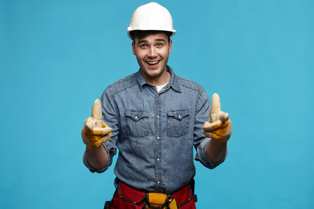头盔水平拍摄的年轻漂亮的未刮胡子的男建筑工人戴着安全帽男性建筑工人衬衫