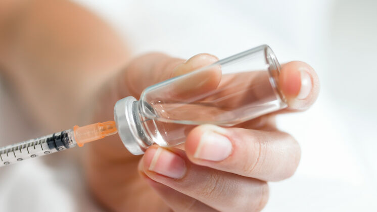 填充女医生从玻璃瓶往注射器里灌药的特写镜头健康针头手臂