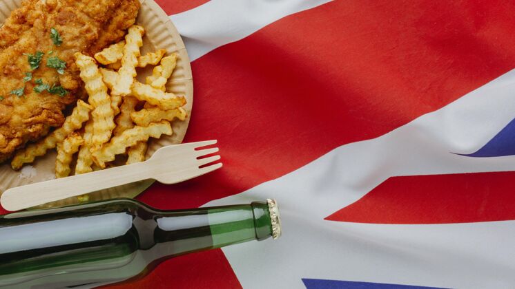 瓶子盘子上的鱼和薯条的俯视图 上面有啤酒瓶和英国国旗油炸菜伟大的英国