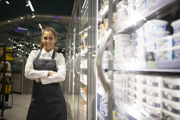冰箱超市工作人员在安排冷冻鱼出售女性杂货店杂货店工人