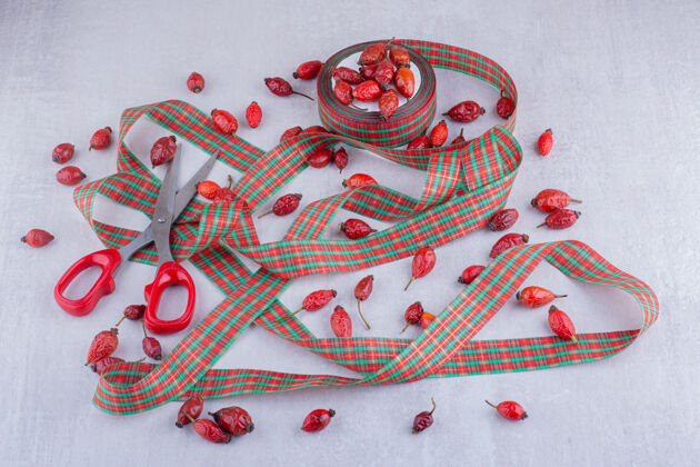 臀部白色背景上的圣诞糖果色丝带和狗玫瑰果装饰水果圣诞节