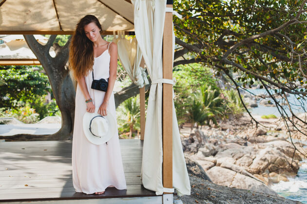 夏天年轻的自然美丽的女人在灰色长袍在天棚摆姿势 热带度假 草帽 性感 夏季服装 度假胜地 波西米亚复古风格帽子海滩摄影师