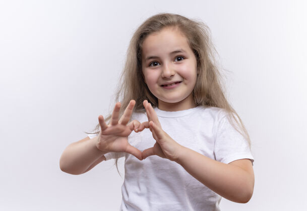 心微笑的小女生穿着白色t恤 在孤立的白色背景上展示心形小女孩手势
