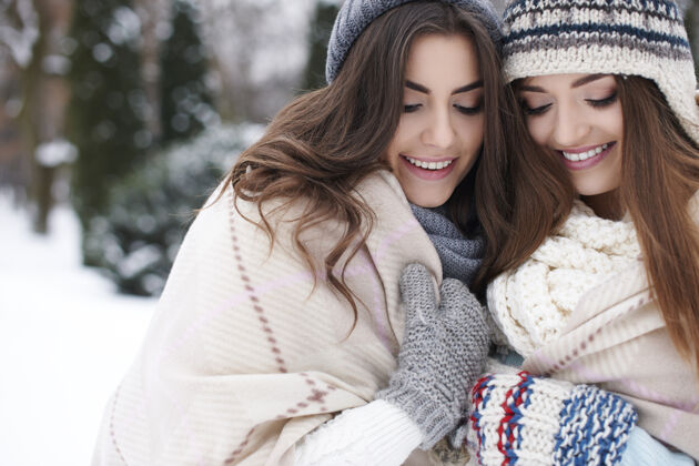 看自然的女人在冬天的毛毯下暖包裹拥抱