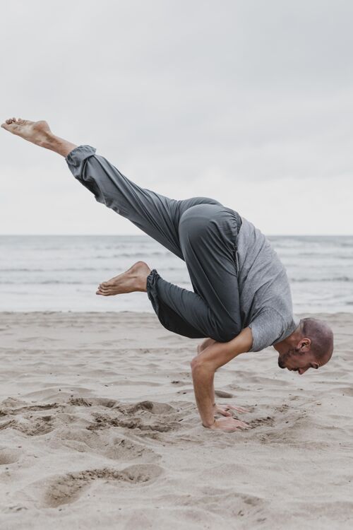 专注海滩上练习瑜伽姿势的男子侧视图男人冥想垂直