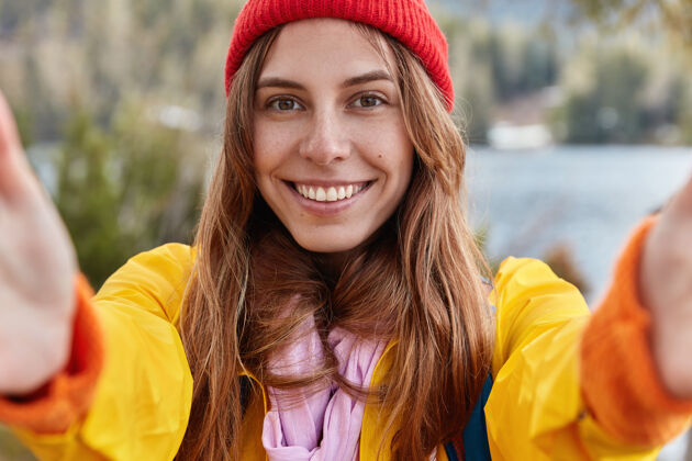 休息快乐女孩儿自画像 欧式容貌 迷人的笑容 戴着红帽子 穿着黄色的休闲服 边走边探索世界雨衣女性帽子