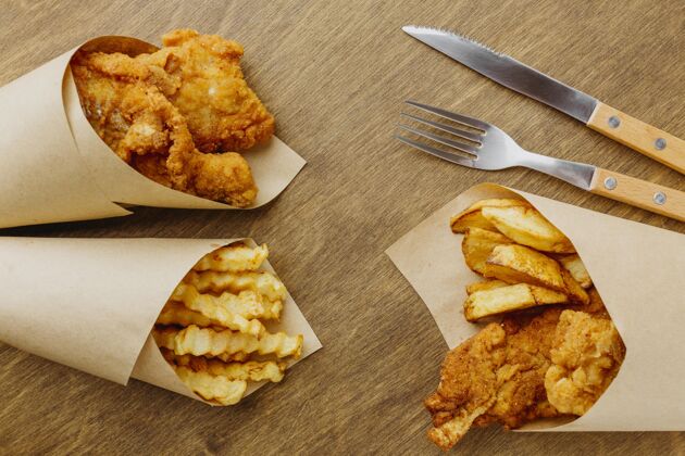 餐带餐具的纸包装鱼和薯条的俯视图美食油炸土豆
