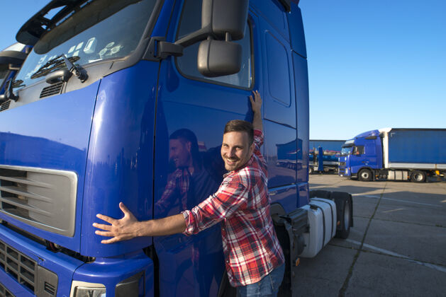 微笑卡车司机抱着他的卡车运输人货物拥抱