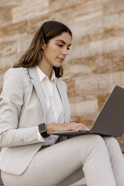 女士优雅的女商人用智能手表在笔记本电脑上工作优雅个人个人