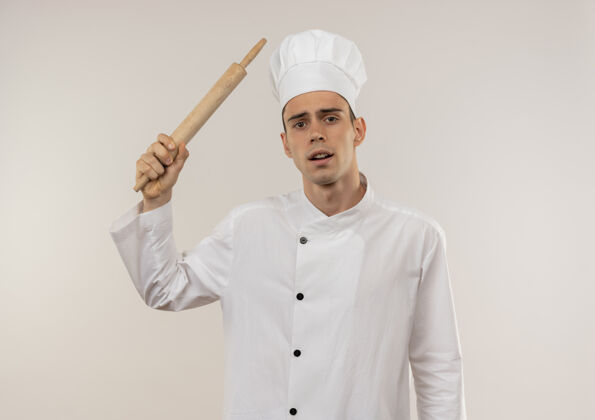 悲伤悲伤的年轻男厨师穿着厨师制服 肩上扛着擀面杖穿制服肩