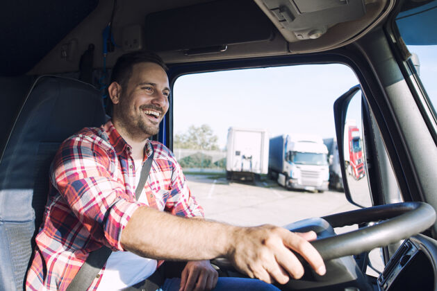 卡车运输专业的中年卡车司机 穿着休闲服 驾驶卡车 运送货物到目的地微笑卡车集装箱
