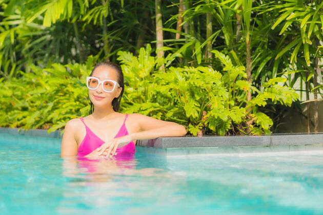 身体肖像美丽的亚洲年轻女子放松微笑周围的室外游泳池在酒店度假村泳装放松放松