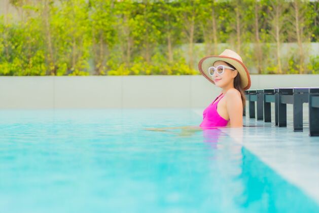 美丽肖像美丽的亚洲年轻女子放松微笑周围的室外游泳池在酒店度假村泳装休闲亚洲