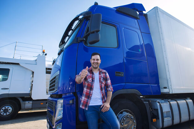 工人专业卡车司机站在长距离运输车辆前竖起大拇指准备新的旅程卡车物流站立