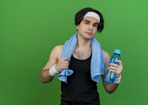 水穿着运动服 头戴头巾 脖子上围着毛巾 手里拿着一瓶水 表情严肃的年轻人男人周围头带