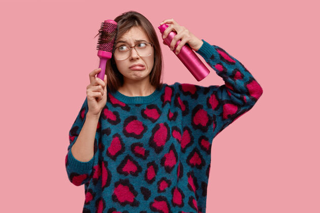 发型不高兴的年轻女模特室内拍摄头发有问题 做发型 用发刷梳头 有挫败感刷子不喜欢眼镜